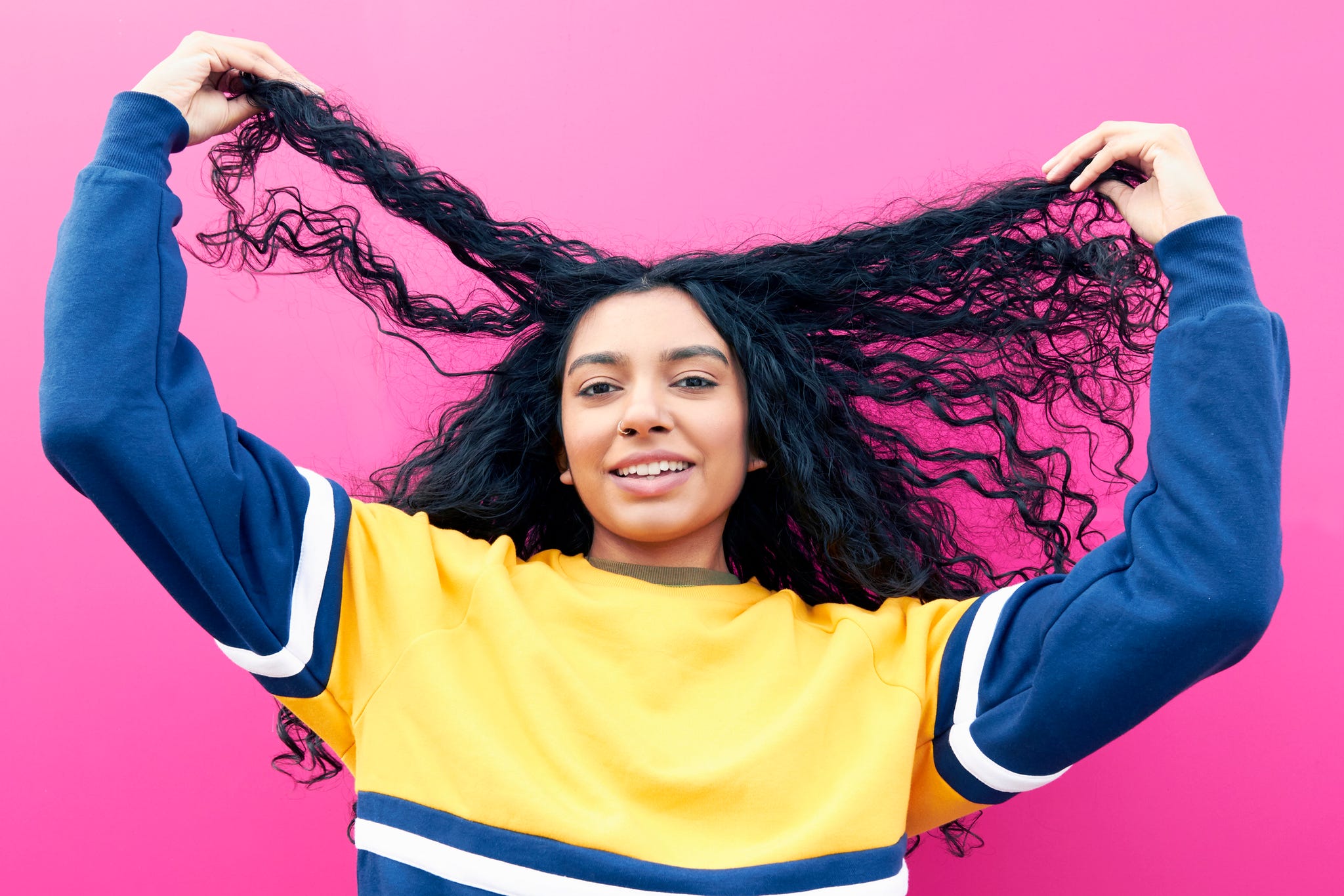 young woman holding her hair and laughing