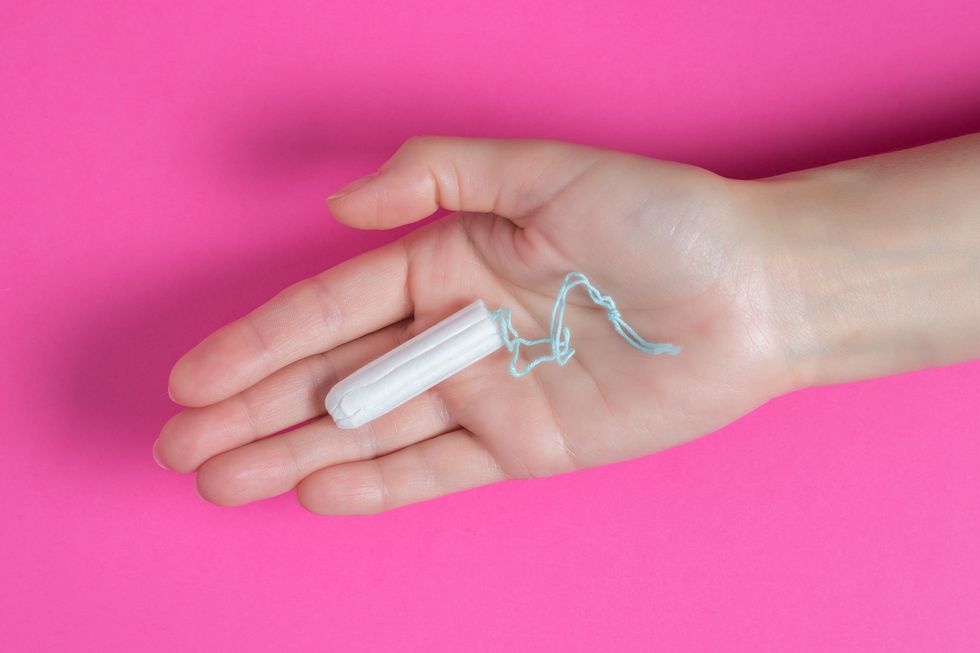 young woman holding menstruation tampon in hand women's menstrual cramps menstruation, means of protection