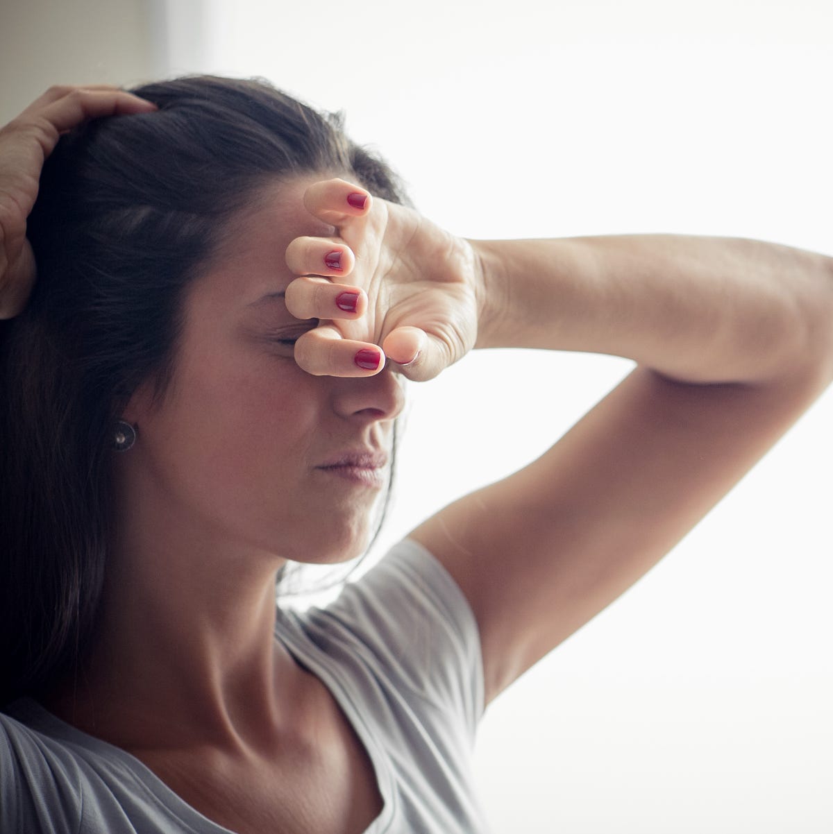 young woman holding one hand on forehead