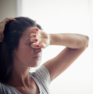 Young woman holding one hand on forehead