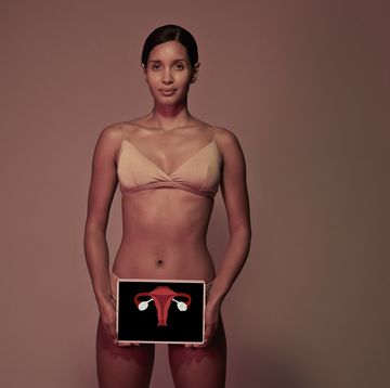 young woman holding tablet in front of body to show womb ovaries