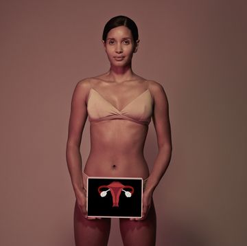 young woman holding tablet in front of body to show womb ovaries