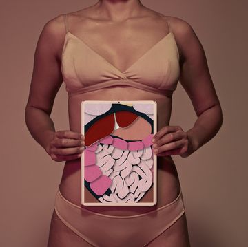 young woman holding tablet in front of stomach to show intestines