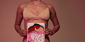 young woman holding tablet in front of stomach to show intestines
