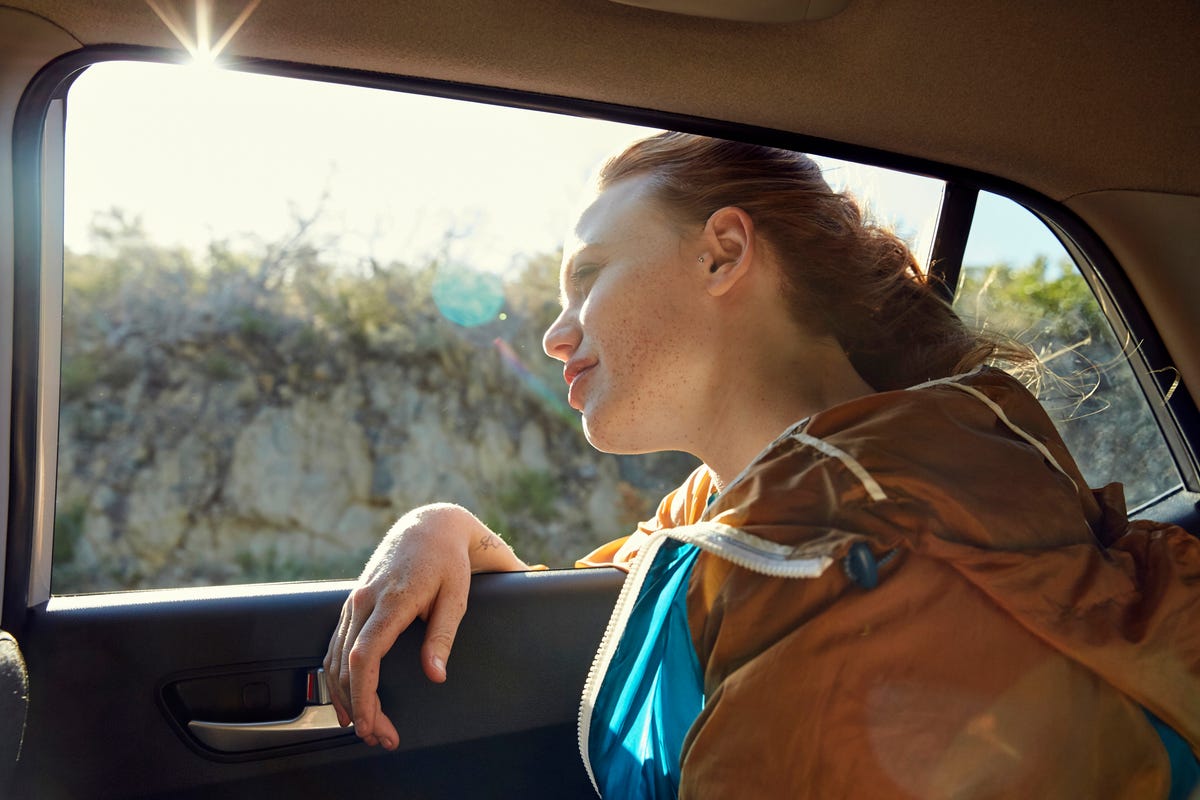 donna nel auto interno svolta in giro guardare a viaggiatori nel indietro  posto a sedere idea Taxi autista. concetto di esame veicolo. indietro  Visualizza di un attraente giovane donna guardare al di