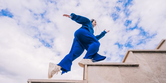 https://hips.hearstapps.com/hmg-prod/images/young-woman-in-blue-suit-running-up-the-stairs-on-royalty-free-image-1733852350.pjpeg?crop=1xw:0.75007xh;center,top&resize=640:*