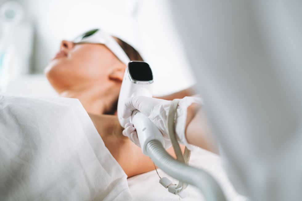 primer plano de una mujer en una camilla sometiendose a depilacion con laser en una axila