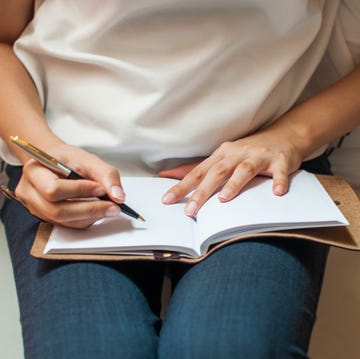 a young woman is writing on her personal organizer