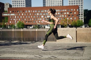 young woman jogging at waterfront in city