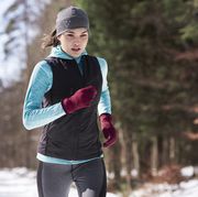 Young woman jogging in winter forest