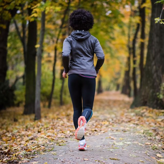 young woman jogging through the fall park