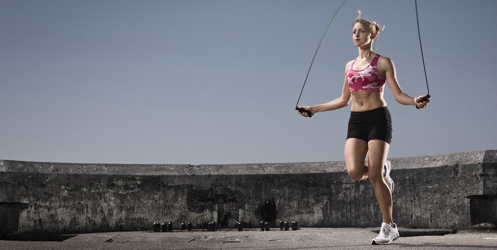 young woman jumping rope outdoors