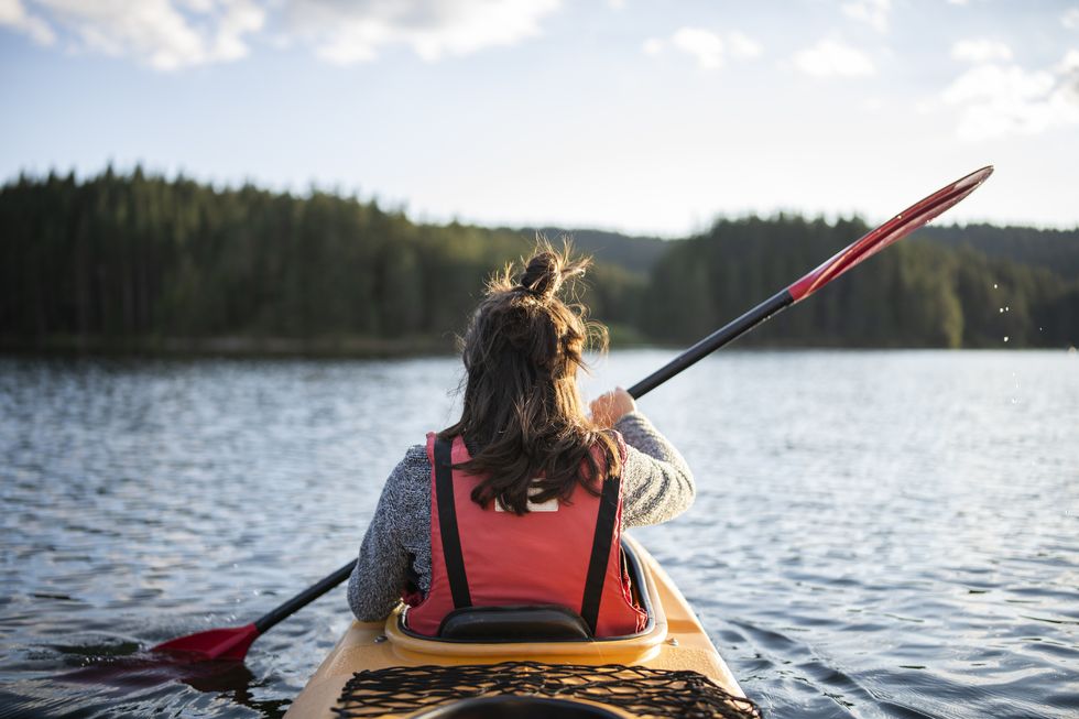 young woman kayaking in a mountain lake