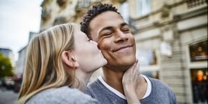 young woman kissing boyfriend in the city