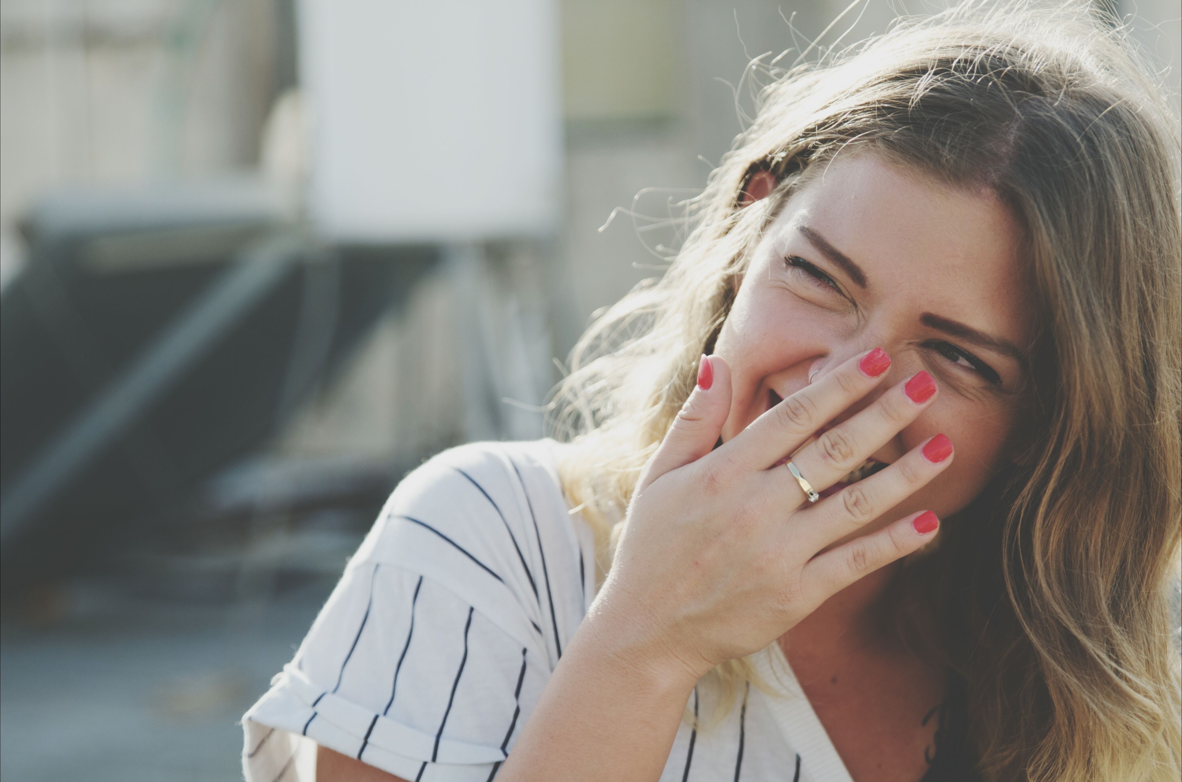 young woman laughing while hiding mouth with hand royalty free image