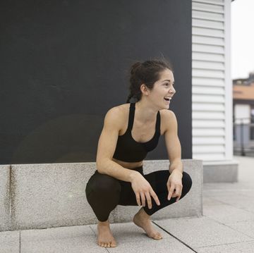 young woman laughing while is crouched down