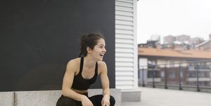 young woman laughing while is crouched down