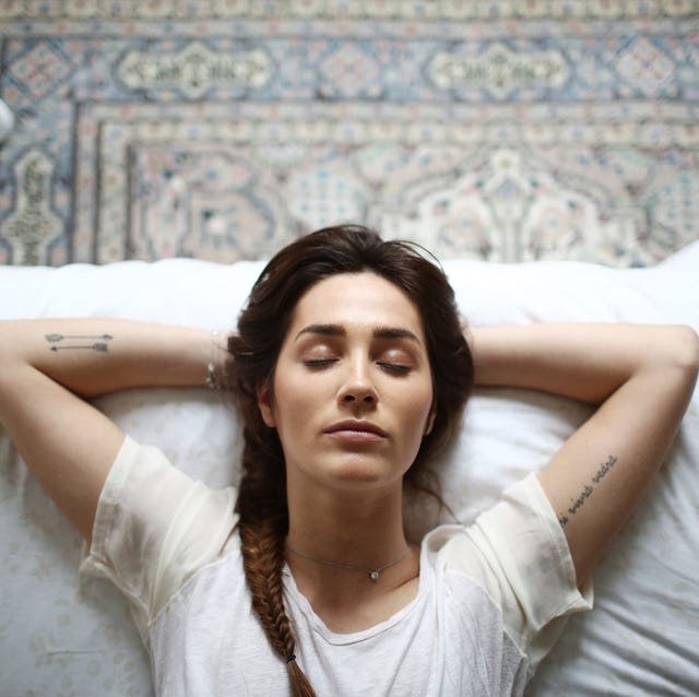 a young woman laying on her bed