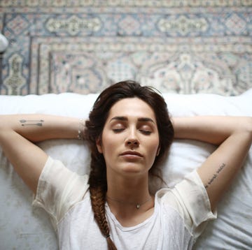 a young woman laying on her bed