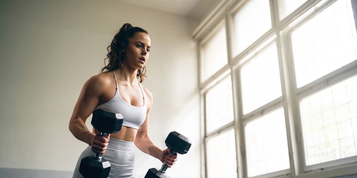 https://hips.hearstapps.com/hmg-prod/images/young-woman-lifting-dumbbells-during-workout-in-a-royalty-free-image-1750241905.pjpeg?crop=1.00xw:0.752xh;0,0.0817xh&resize=1200:*