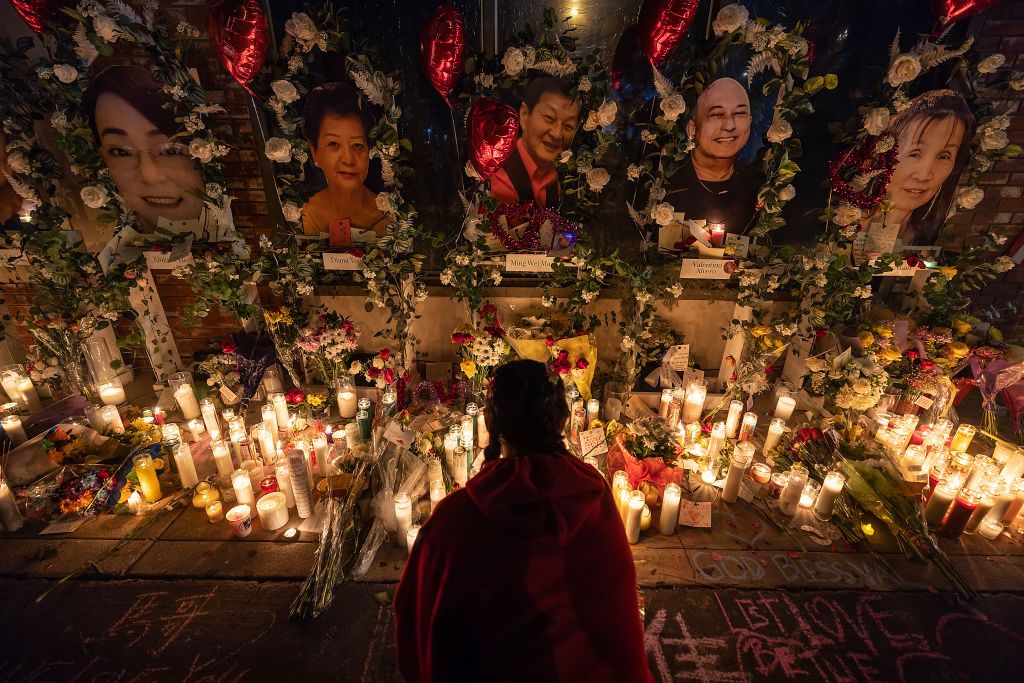 a young woman lights incense at a vigil for those murdered during a mass shooting at star ballroom dance studio in monterey park, california