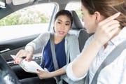 Young woman listens to instructions before driving test