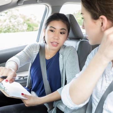 Young woman listens to instructions before driving test
