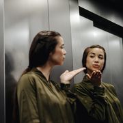 narcissist quotes young woman looking in mirror in elevator blowing a kiss