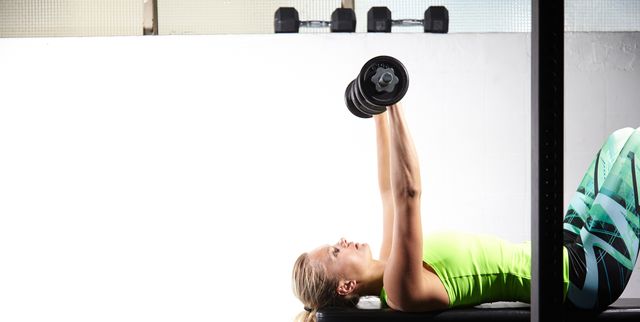 Young Determined Fitness Woman Doing Exercises at Chest Press