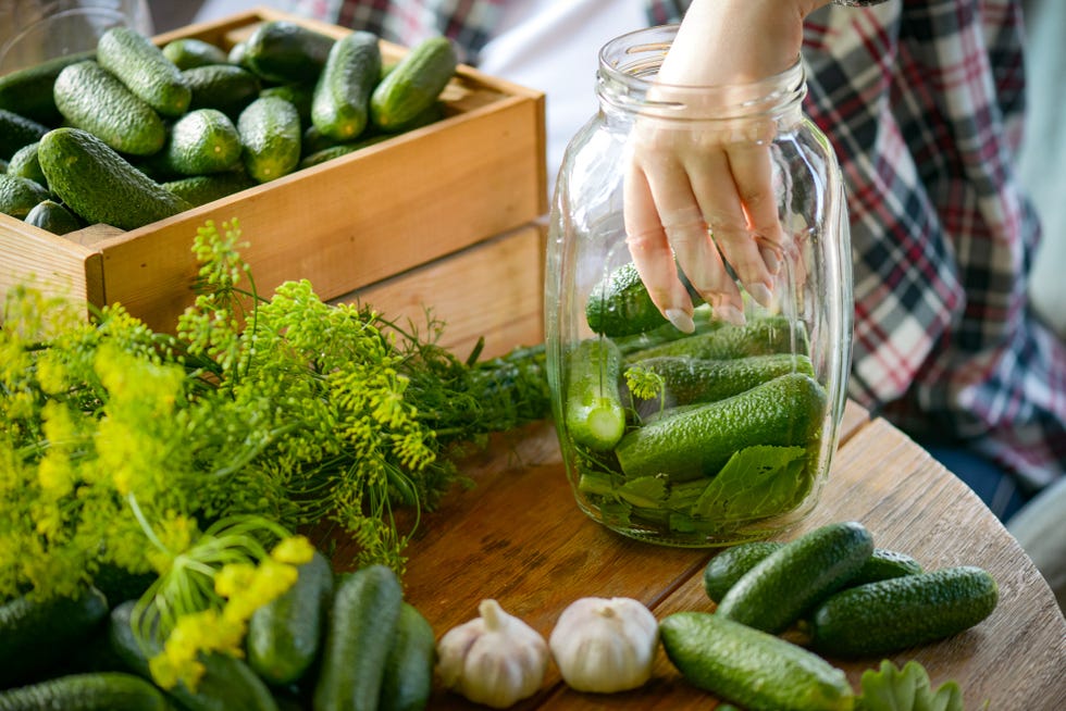 young woman makes homemade pickled cucumber preparations