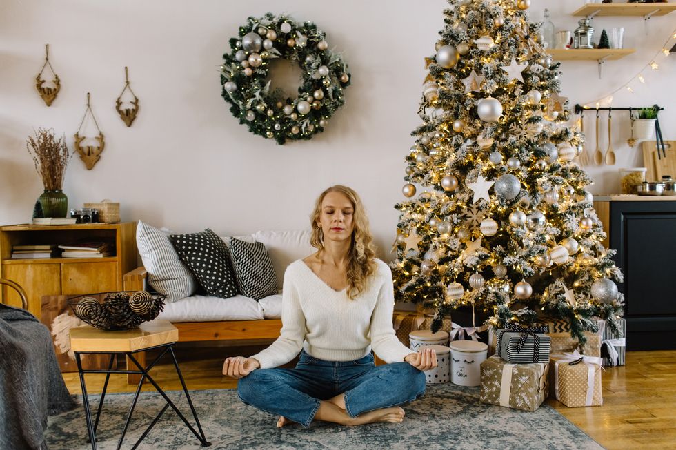 young woman meditates at home during the christmas days