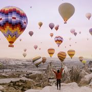 young woman on a background of flying balloons at sunrise in cappadocia
