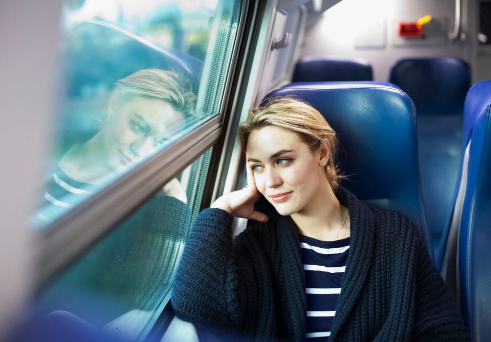 young woman on a train looking out the window