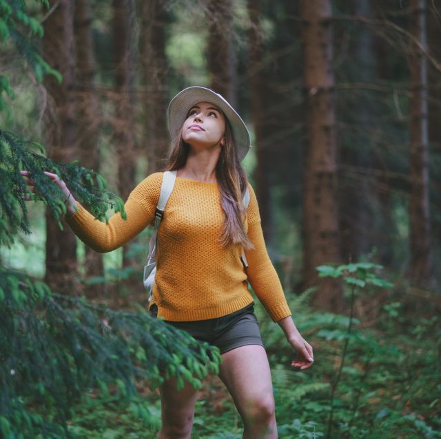 young woman on a walk outdoors in forest in summer nature, walking