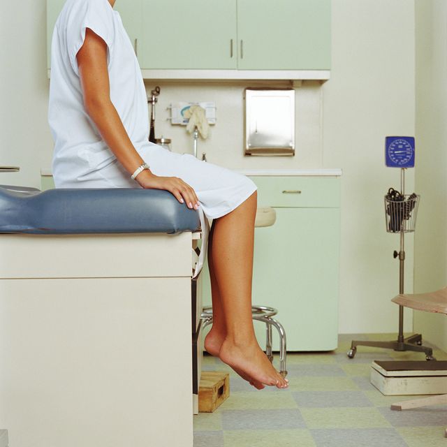 Young woman on table in doctor's office, mid section