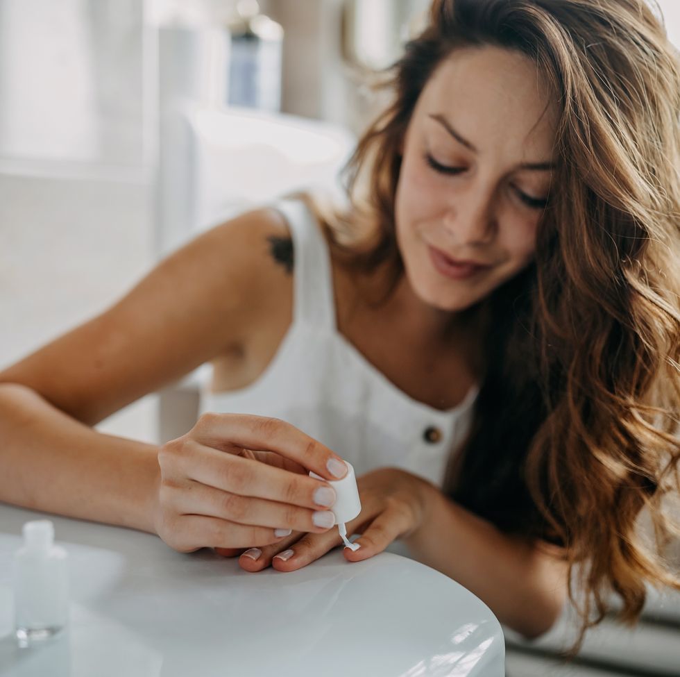 young woman paints her nails