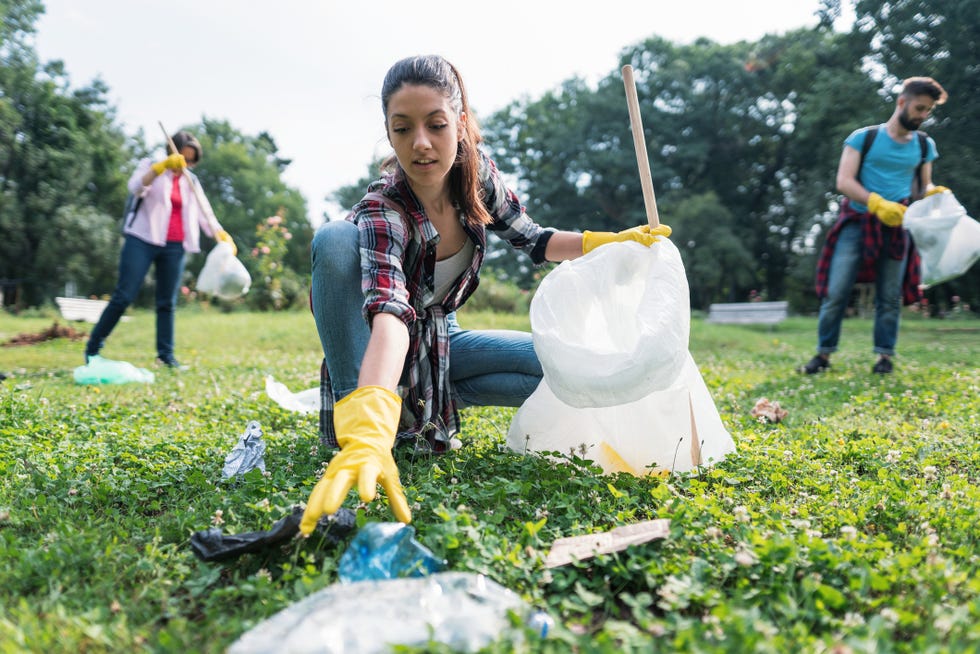 stockfoto van een vrouw die zwerfafval opruimt in een park