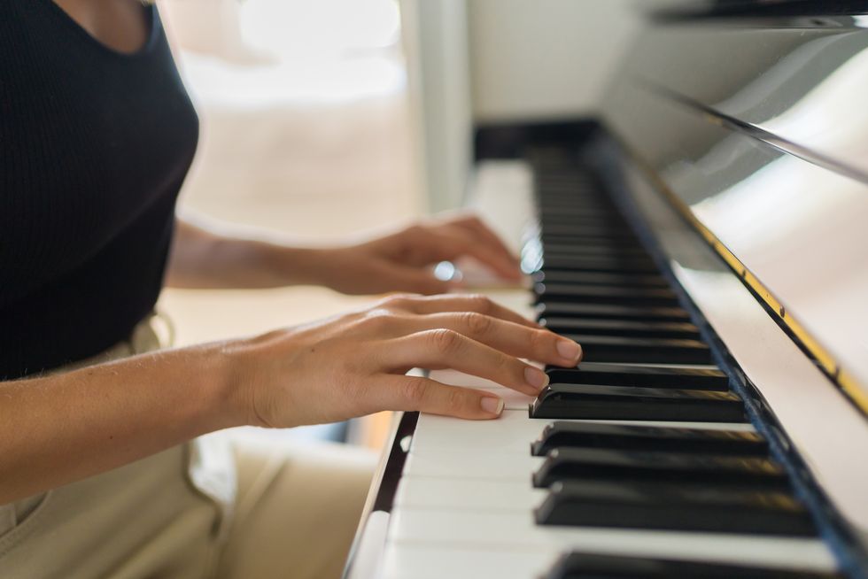 woman plays piano in living room