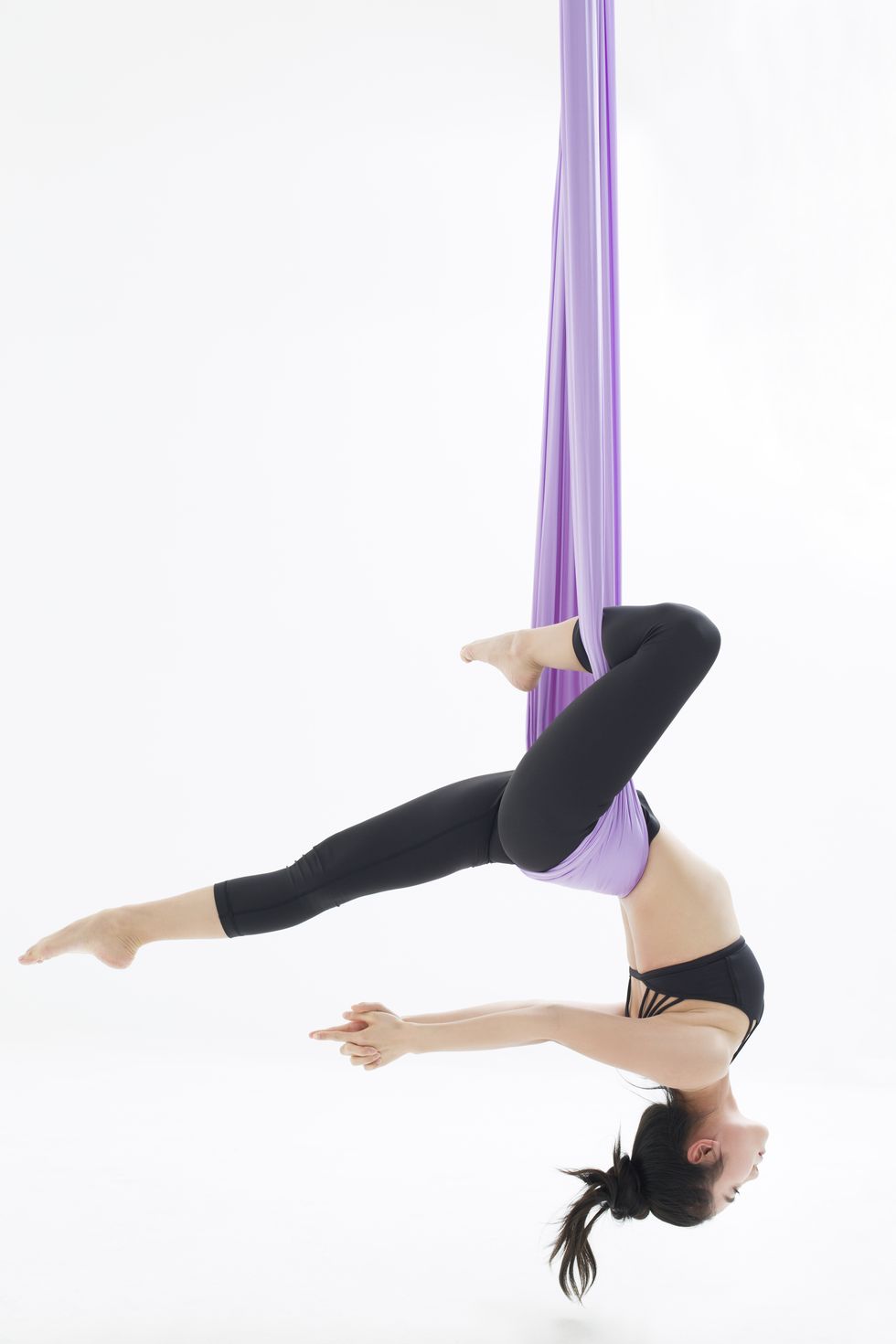 young woman practicing aerial yoga