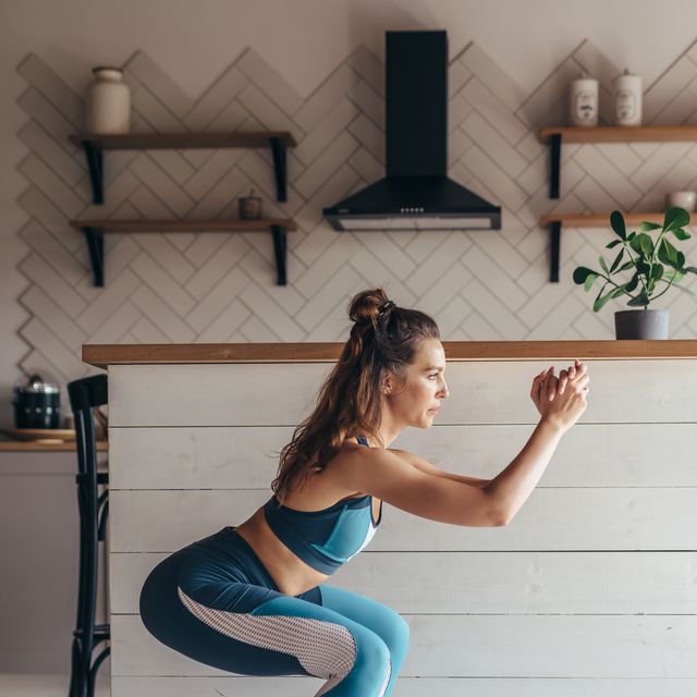young woman practicing squats woman exercising at home