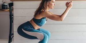 young woman practicing squats woman exercising at home