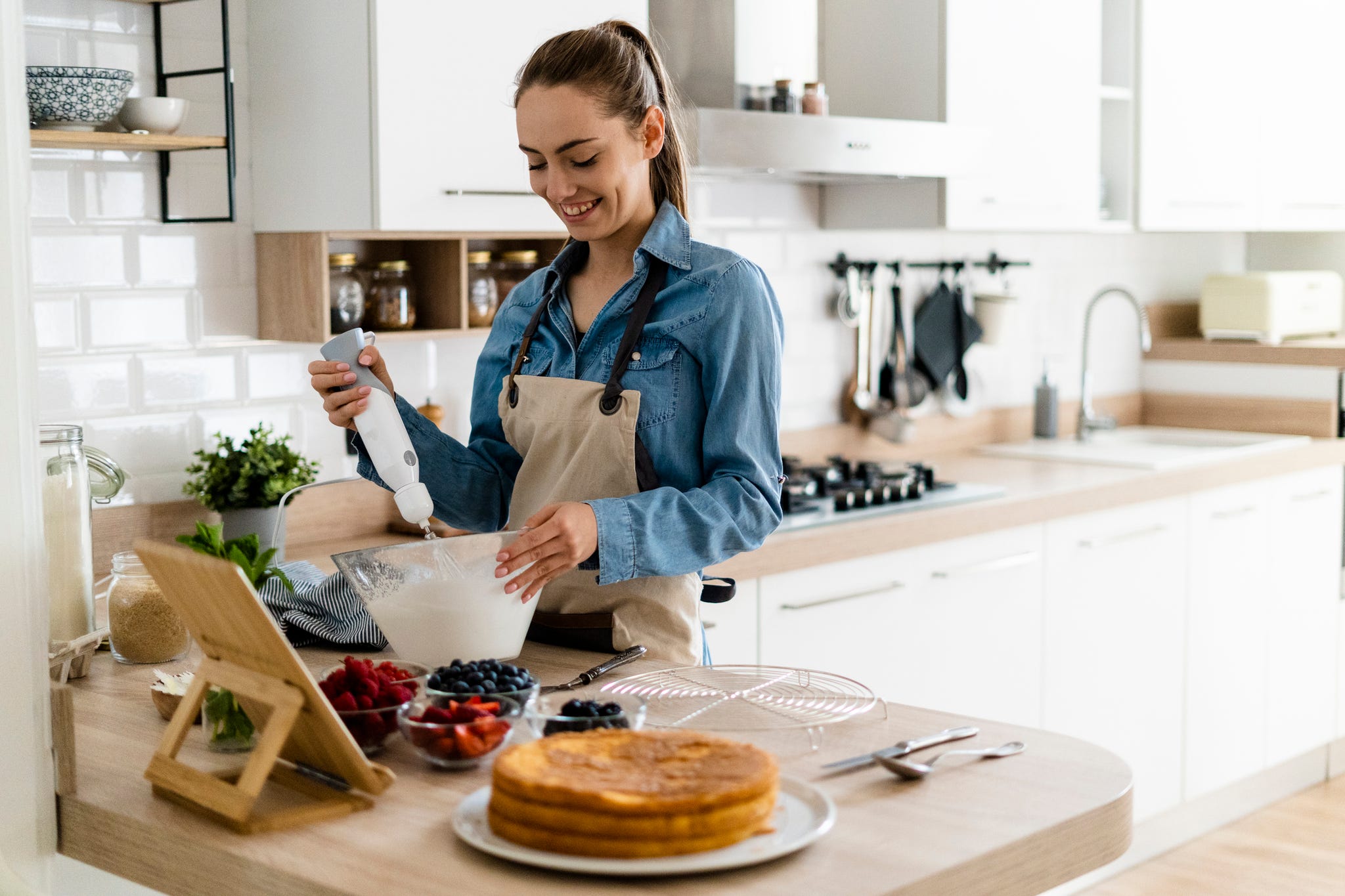 https://hips.hearstapps.com/hmg-prod/images/young-woman-preparing-a-cream-cake-using-tablet-royalty-free-image-1614326661.?crop=0.667xw:1.00xh;0.0323xw,0&resize=2048:*