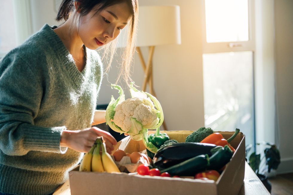 young woman receiving fresh food home delivery