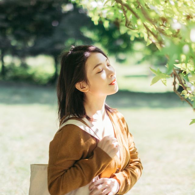 young woman relaxing in nature with eye closed