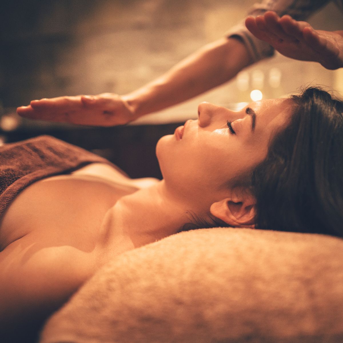 young woman relaxing with body and face massage at spa