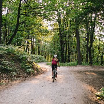 young woman rides gravel bicycle on rural track