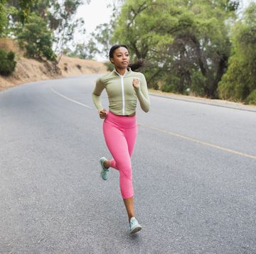 young woman running along rural road