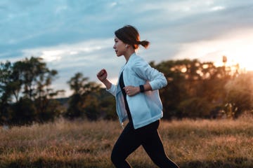 young woman running at the park at sunset