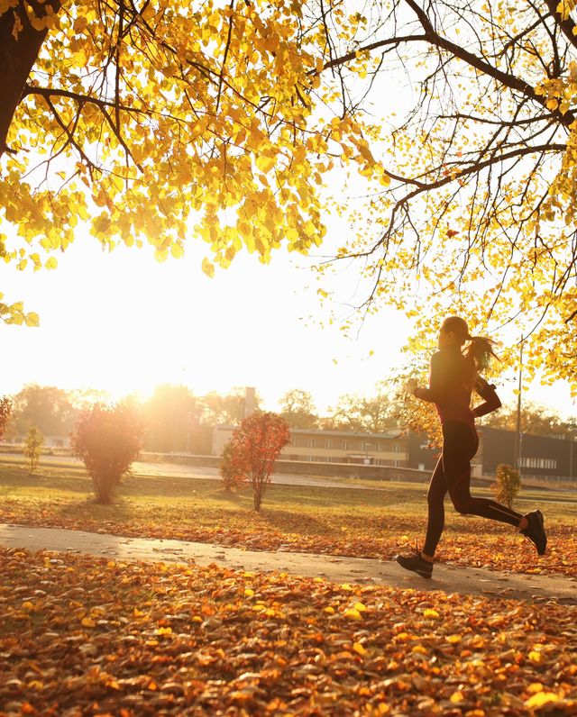 Young woman running in park, autumn
