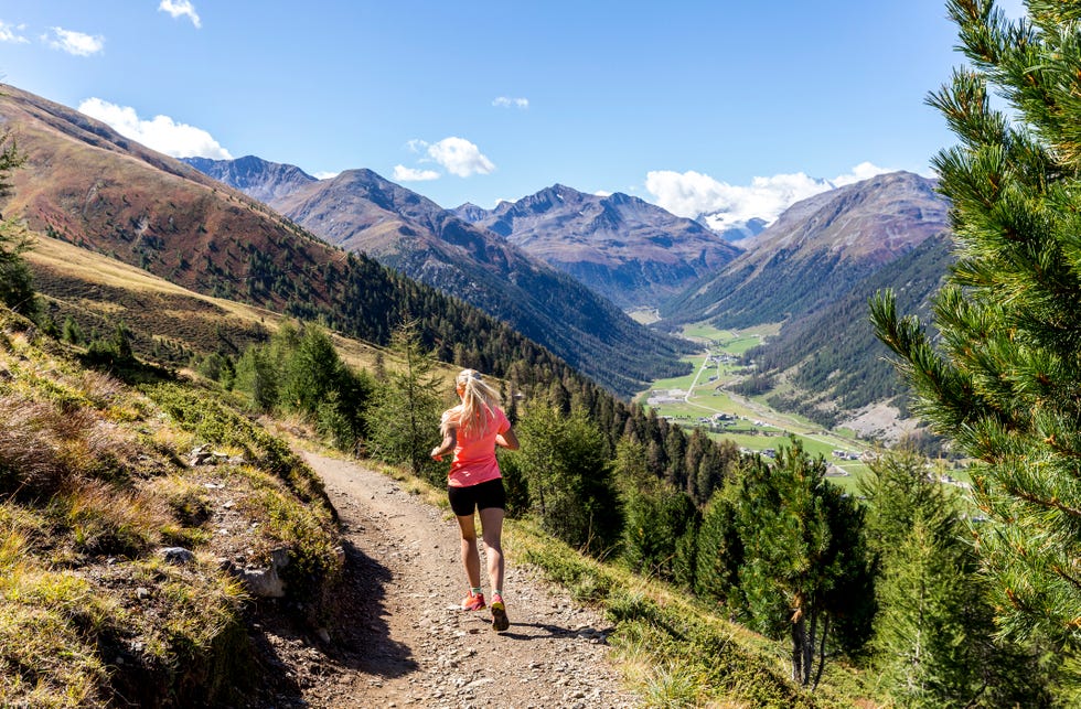 young woman running on a mountain path